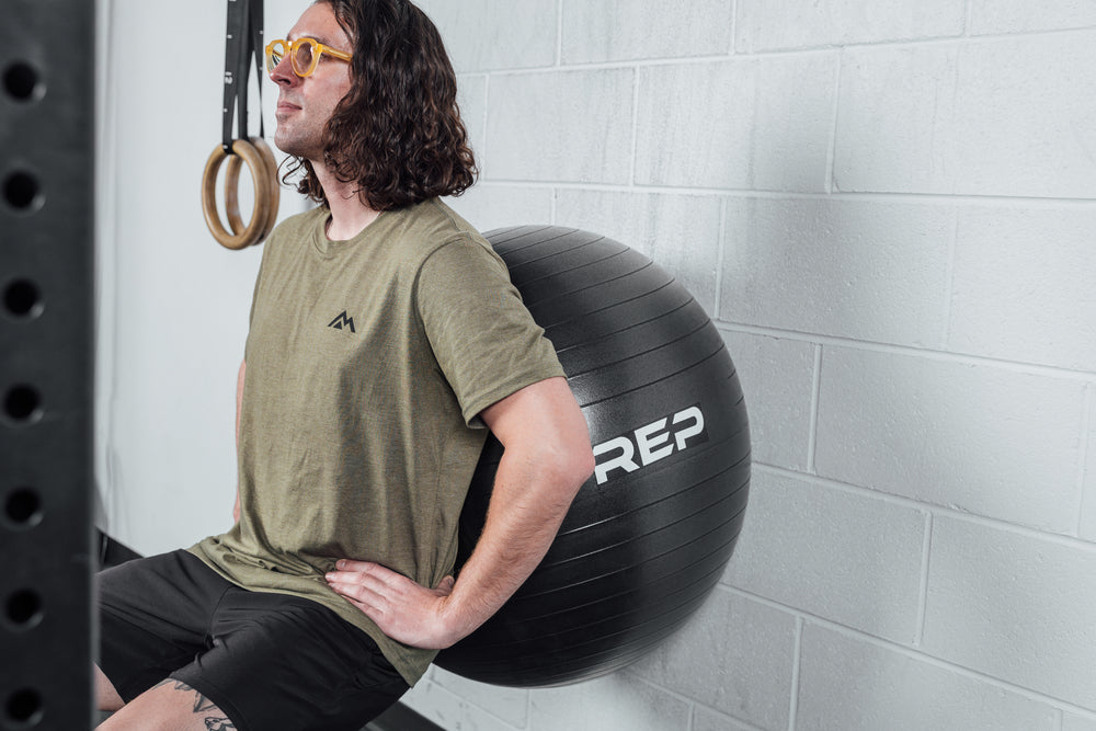 An athlete performs wall squats with Physioball.