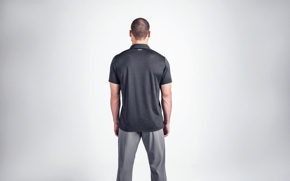 A back shot of an athlete wearing the REP Audax Polo in 
Heather Black. The REP branding is sized to fit subtly below 
the collar on the rear of the shirt