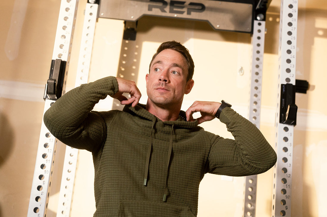 Athlete adjusts their hoodie in the gym.