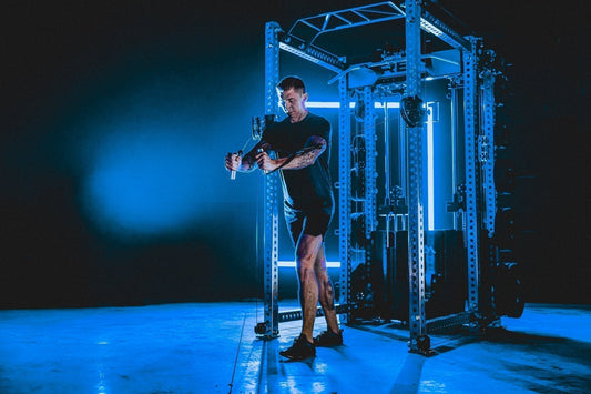 A man uses a REP Fitness power rack home gym.