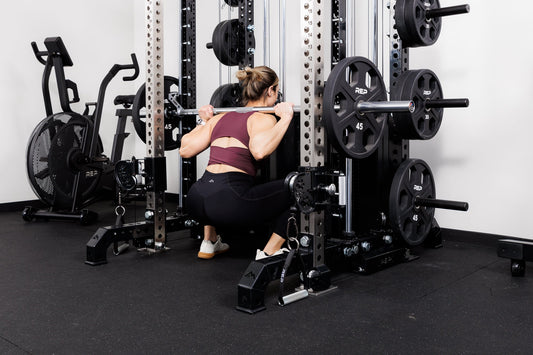 Athlete back squats on REP equipment.