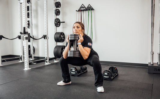 Woman squatting with adjustable dumbbell