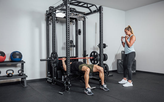 Two athletes work out on the REP® ARES™ 2.0 cable attachment and the power rack it's attached to.
