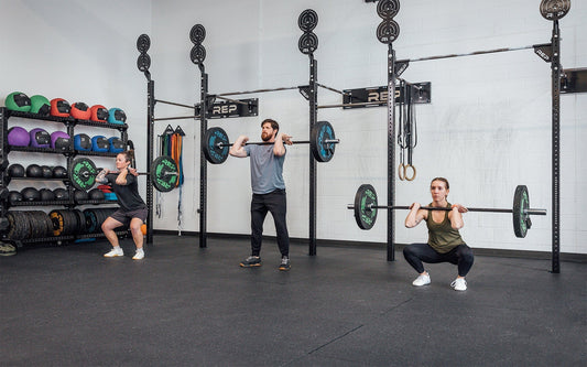 Three athlete use REP barbells for front squats.