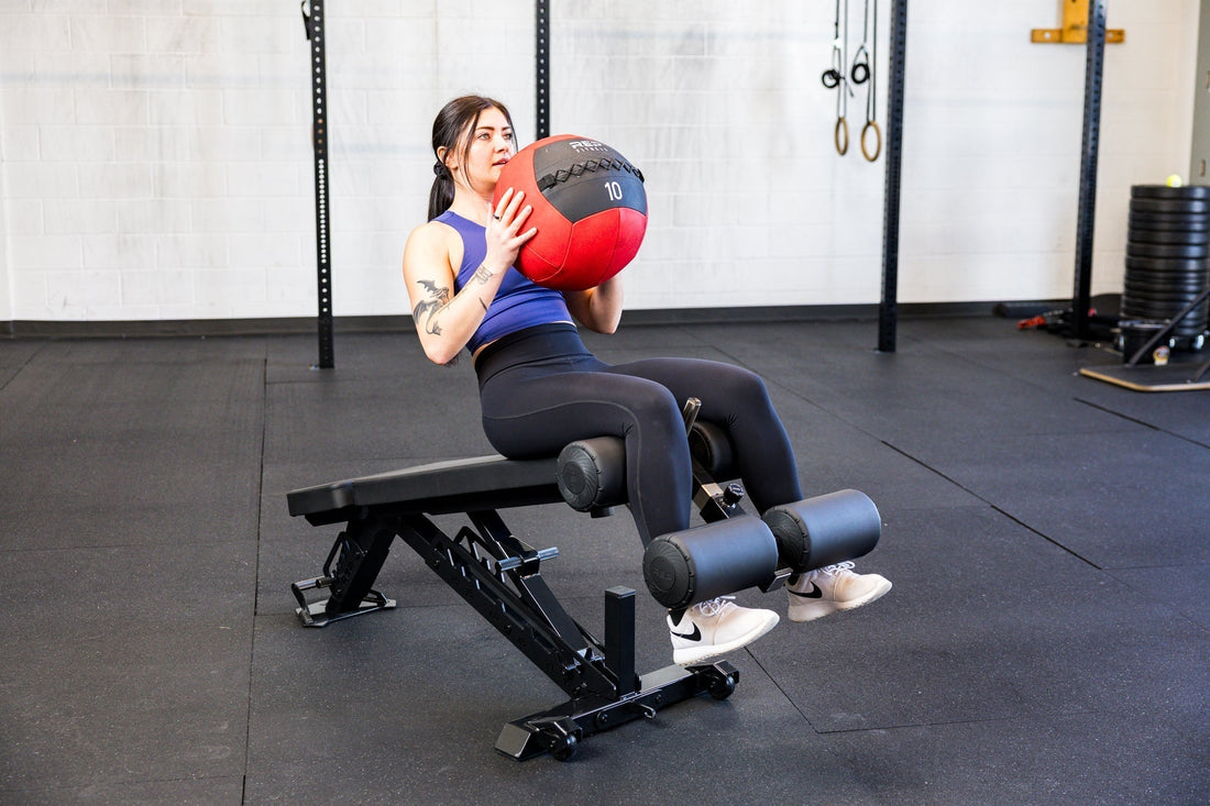 An athlete does core work on a decline bench with the REP® medicine ball.