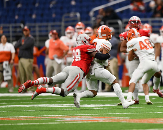 Football player makes a tackle during a game.