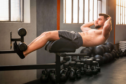 An athlete completes GHD sit-ups in a well-stocked gym.