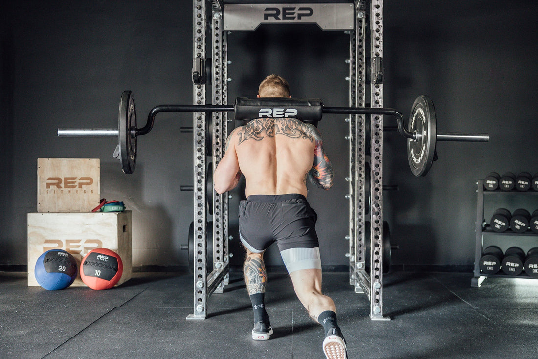 Man doing lunges on a safety squat bar