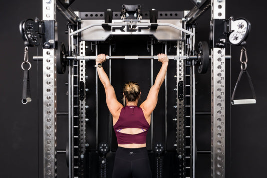 An athlete presses overhead using the REP® Smith Machine attachment.