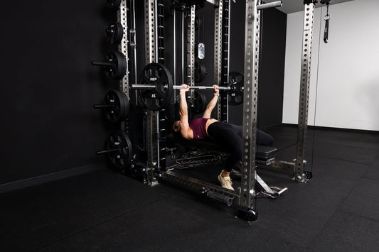 Athlete does bench press with a Smith machine.