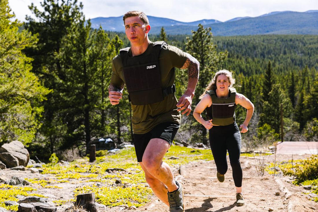 Two athletes run on a trail in the Strata™ Weight Vest.