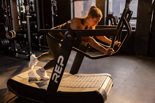 Athlete tackles sled push on Strive™ Curved Treadmill.