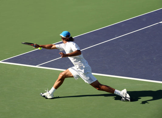 A man reaches for a shot during a tennis match.