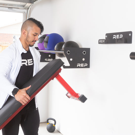 Man storing a bench against the wall