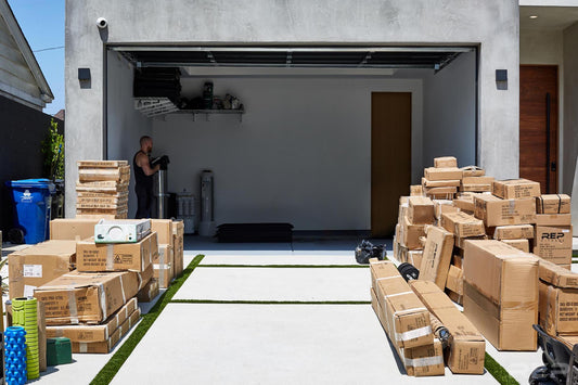 Boxes of gym equipment outside of an empty garage