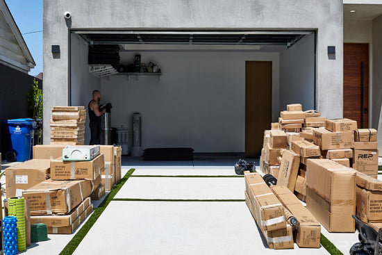 Boxes of gym equipment outside of an empty garage