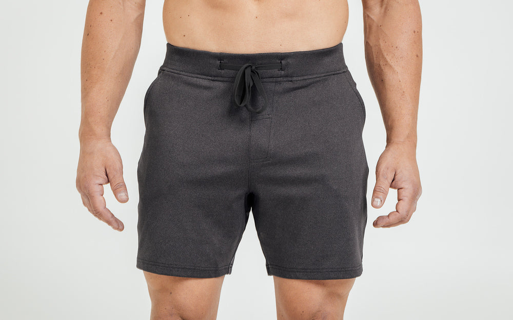 Front view of model wearing the heather black REP Versa Shorts.