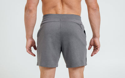 Back view of model wearing the heather cool gray REP Versa Shorts.