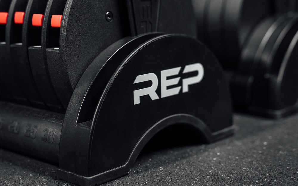 Close-up view of the white "REP" logo on the end of the cradle of your REP Fitness QuickDraw Adjustable Dumbbell (KG).