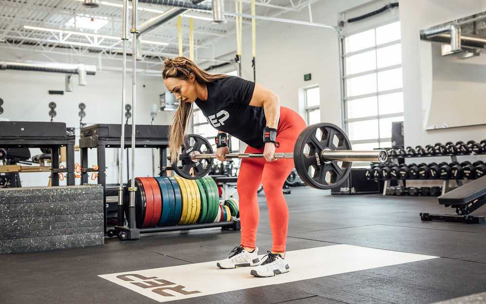 Female lifter performing a bent over row with a loaded REP Double Black Diamond Power Bar.