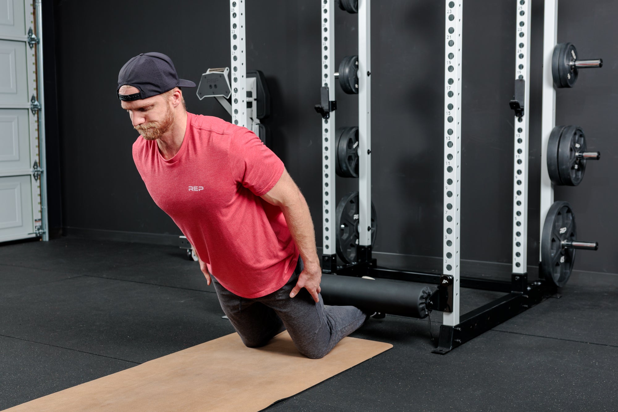 Athlete doing a Nordic Hamstring Curl with the Altitude™ Leg Roller on the Power Rack