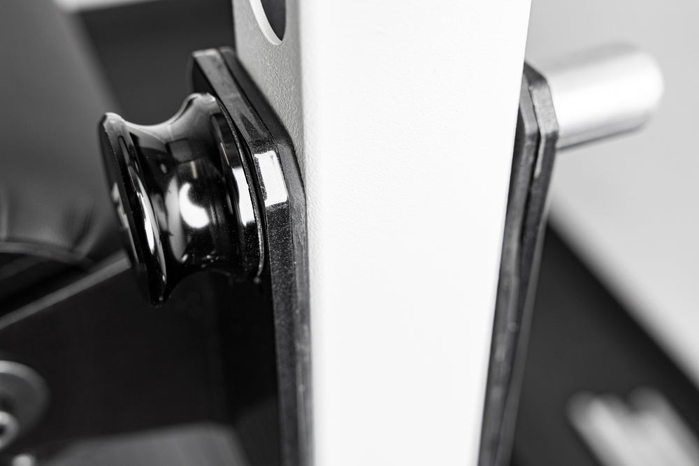 Close-up of the REP Fitness Altitude™ Leg Roller hardware while installed on a rack upright