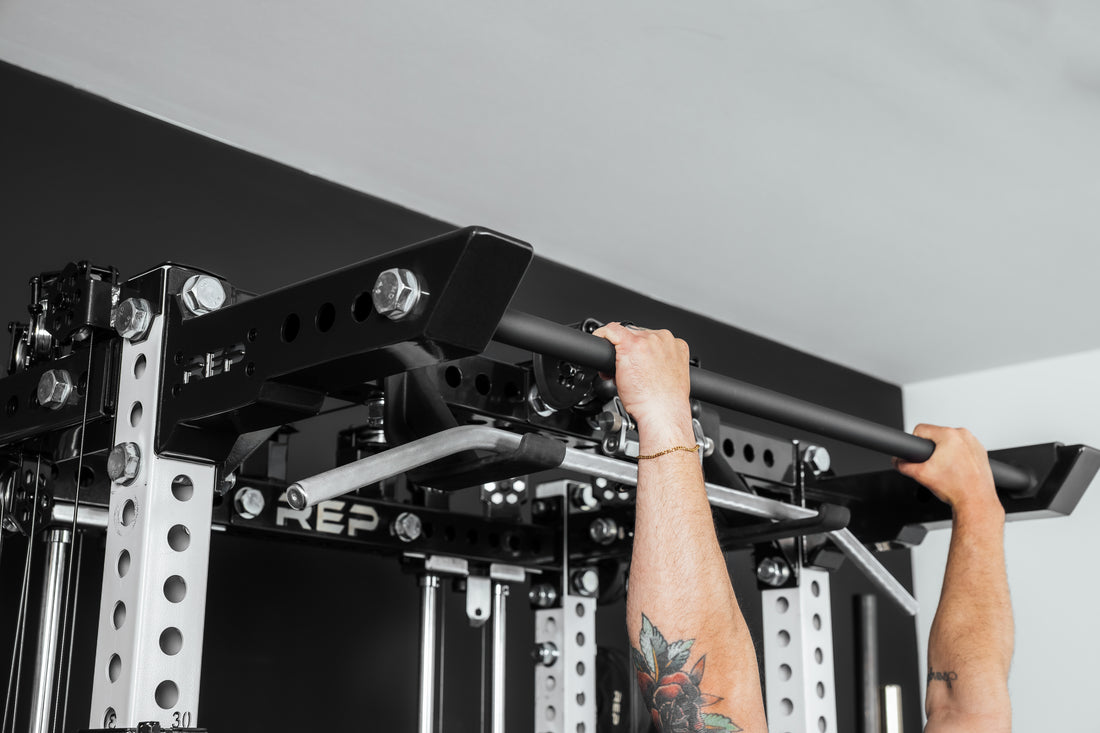 Person performing pull-ups on a pull-up bar (Ares 2.0 4-Post Pull-Up Bar + Pull-Up Bar Extension Brackets).