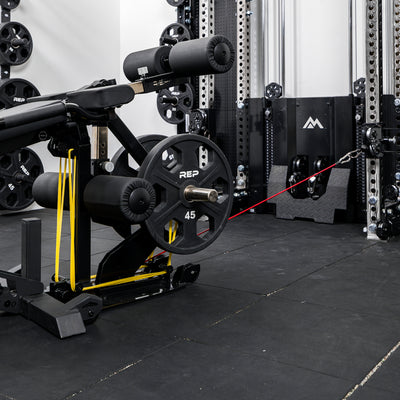 Leg Extension & Leg Curl Bench Attachment Cable Kit being used with weight plates and resistance bands