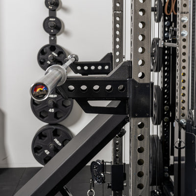 Side shot of a barbell resting on the short Spotter Arms 2.0 set up in a racked position