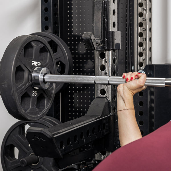 Athlete doing bench press with the standard length Spotter Arms 2.0 as safeties