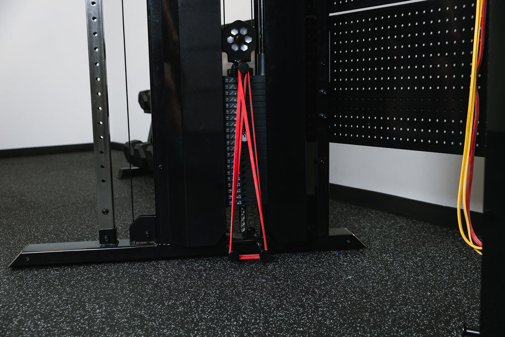 Image of bands being used on the integrated band pegs at the bottom of the weight stack on the black Arcadia™ max