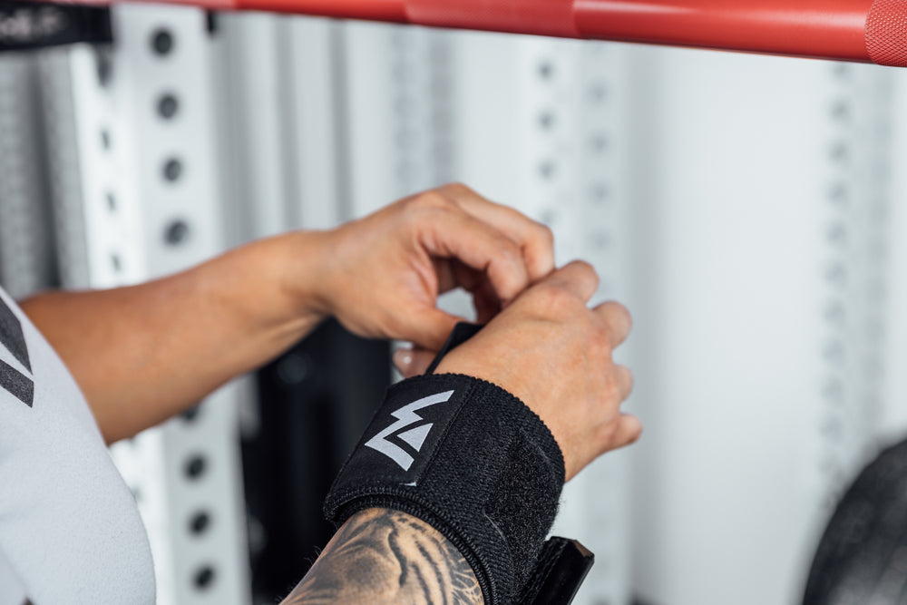 Close up shot of an athlete adjusting the thumb loop of the REP Wrist Wrap