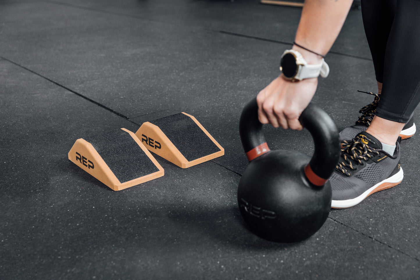Athlete lifting a kettlebell next to Cork Squat Wedges
