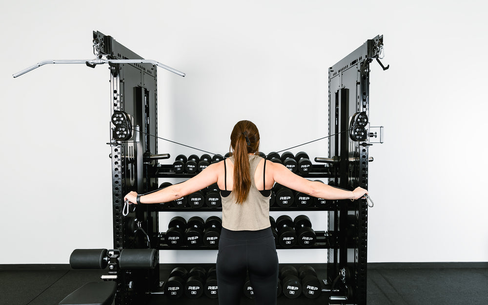 Woman doing reverse flys using both Adonis™ Cable Towers