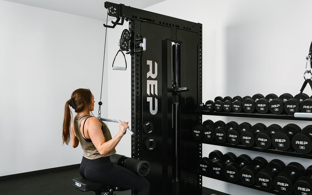 Woman doing lat pulldowns on a single Adonis™ in a dual Adonis™ with Storage setup.