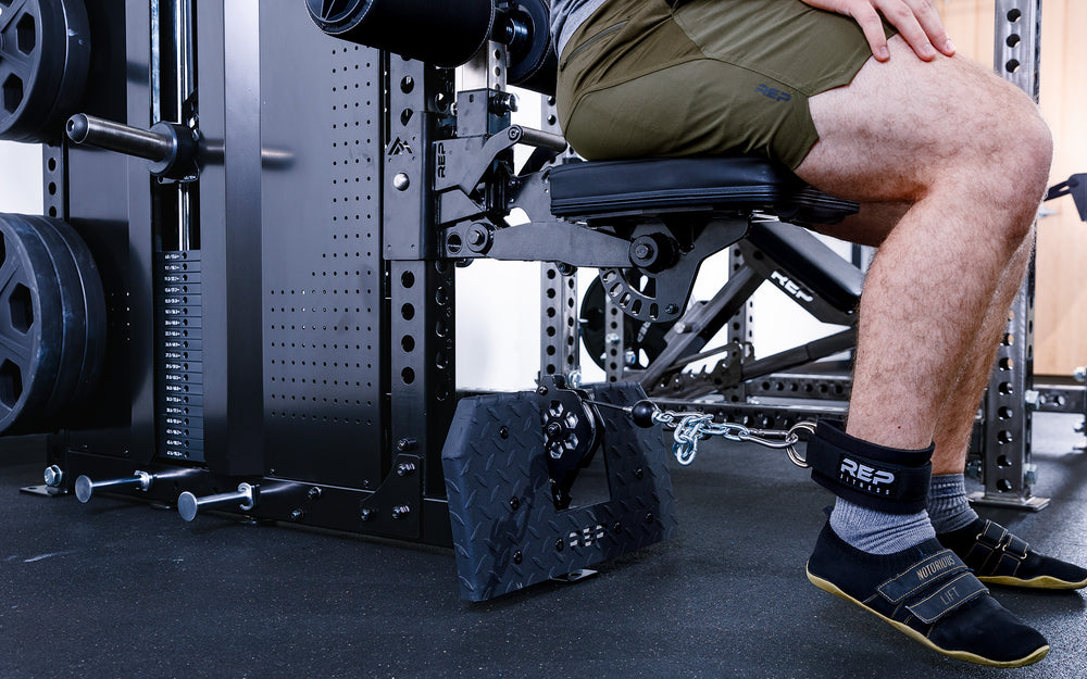 Person using the Pegasus™ Attachment and ankle strap to do leg exercises using the Adonis™ low row.