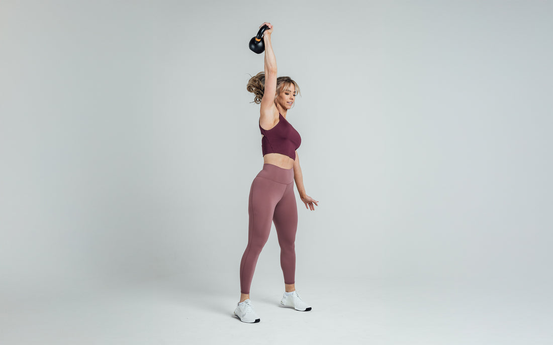 The REP Fitness Women's Rhea Cropped Tank Top in Wine front, kettlebell overhead
