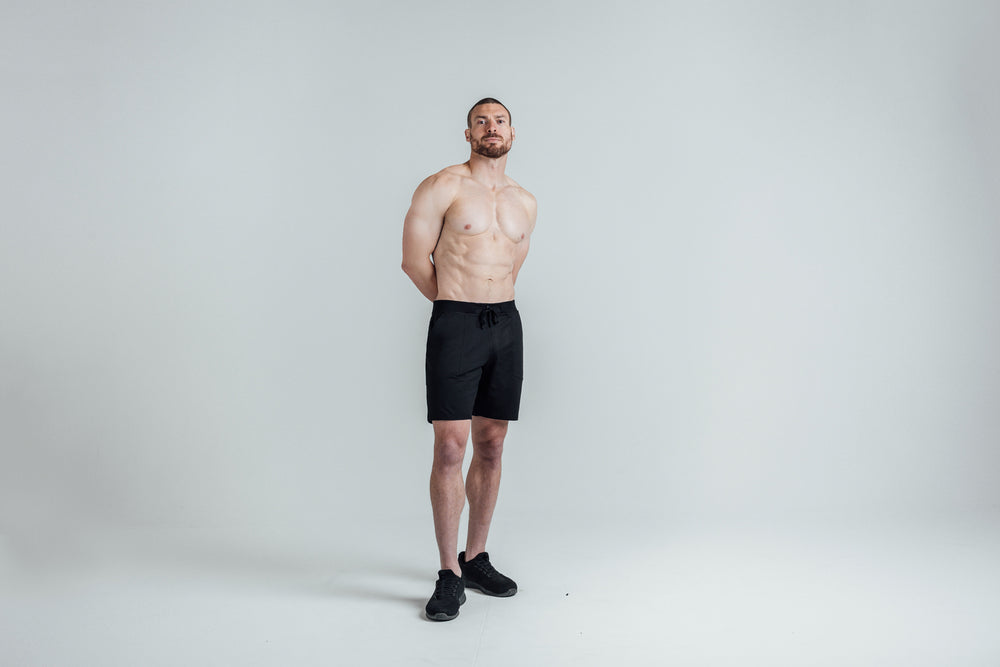 Athlete posing wearing REP’s Men’s Apollo Shorts with a 9 inch inseam in Heather Black/Cool Gray