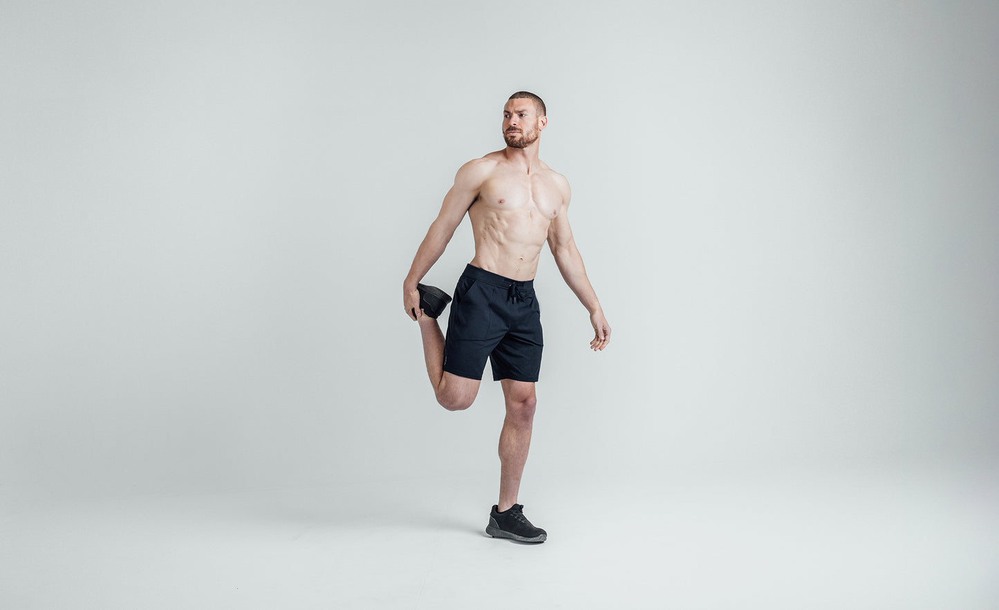 Athlete stretching in REP Men’s Apollo Shorts with a 9 inch inseam in Heather Navy/Cool Gray