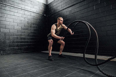 Athlete with battle ropes wearing Heather Olive Sigmatech Tank Top