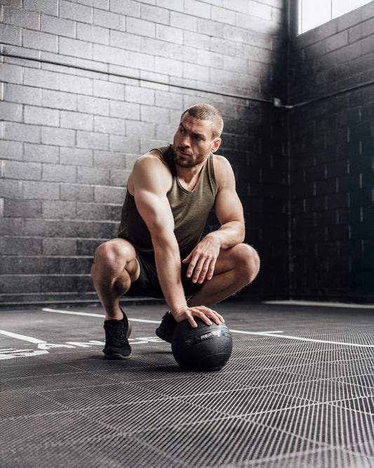 Men's Tanks - Athlete crouched wearing Heather Olive Sigmatech Tank Top
