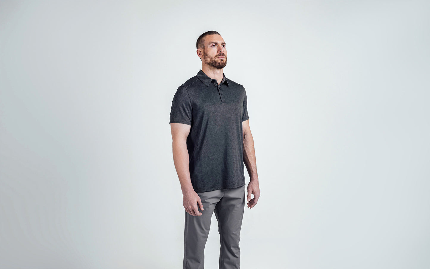 A 3/4 shot of an athlete wearing the REP Audax Polo in 
Heather Black