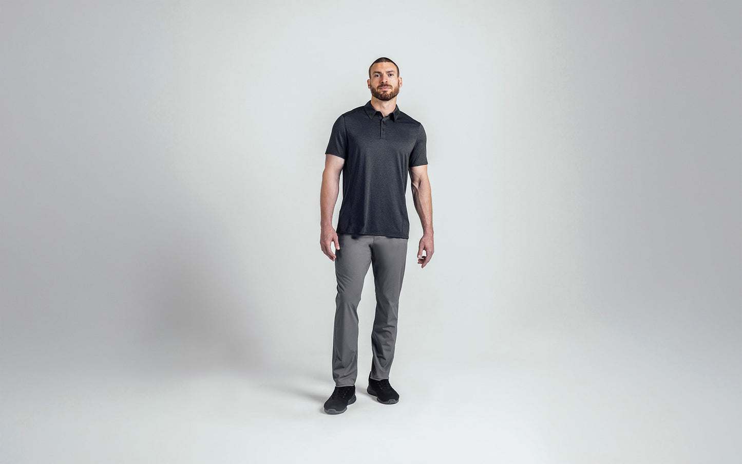 A front shot of an athlete wearing the REP Audax Polo in 
Heather Black