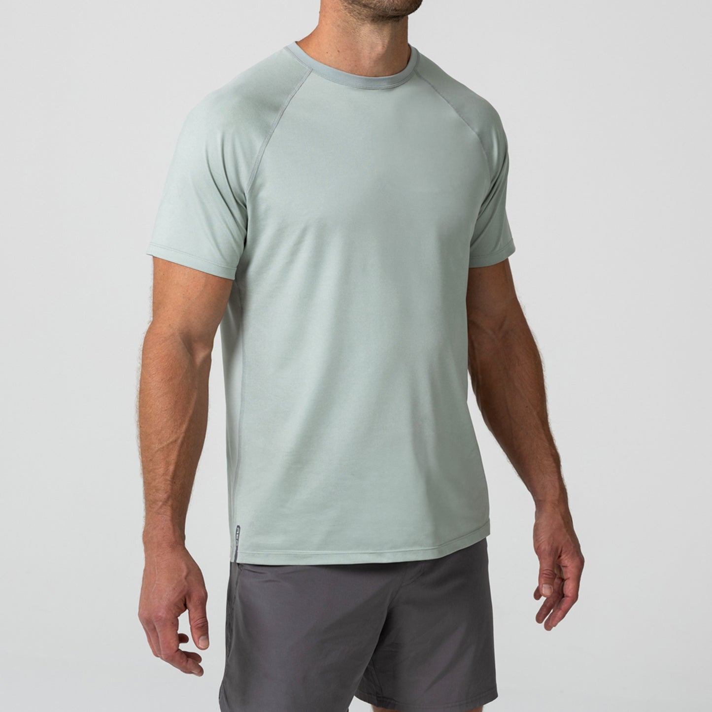 Person wearing an Aqua Gray Men's Aerix athletic shirt and shorts on a white background