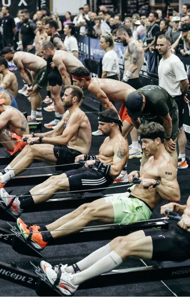 Group of people using rowing machines in a gym setting for a Hyrox event
