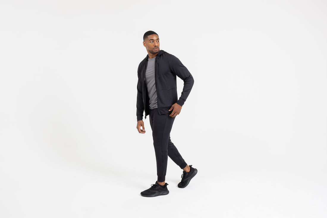 The REP Fitness Men's Attis Joggers in Heather Black front, walking, with jacket