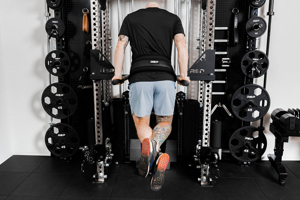 Person using belt squat belt for weighted dips