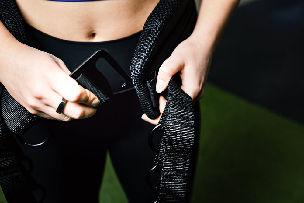 Showing person putting on belt squat belt and the g-hook mechanism.