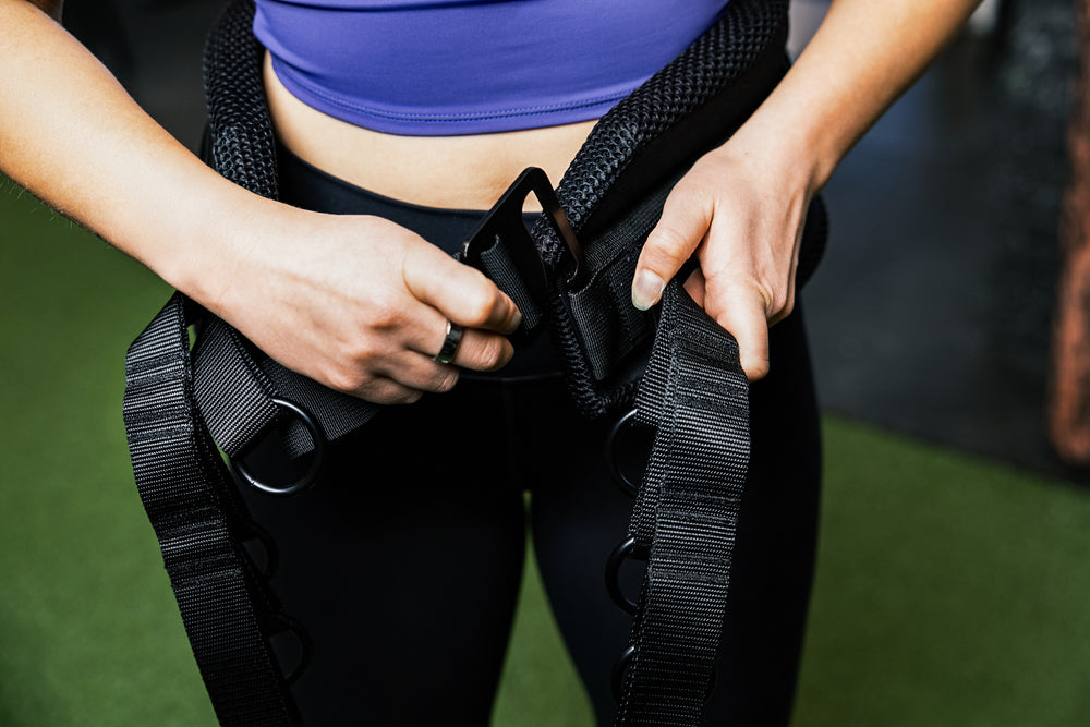 Showing person putting on belt squat belt and the g-hook mechanism.