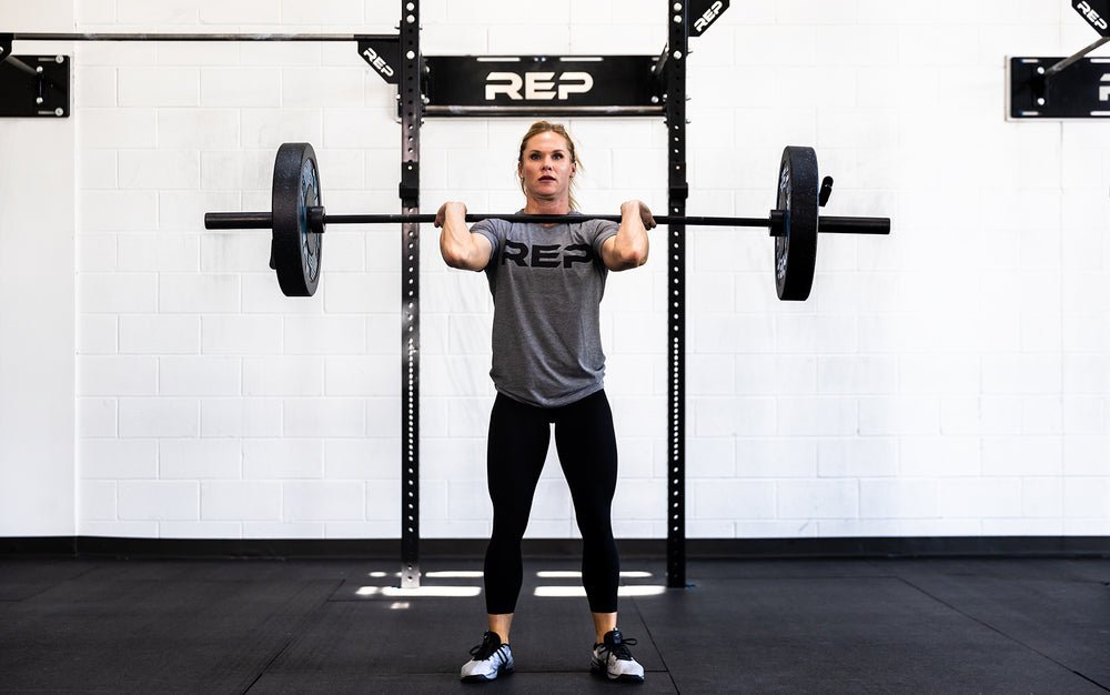 Female lifter with a loaded REP 15kg Colorado Bar in the front rack position.